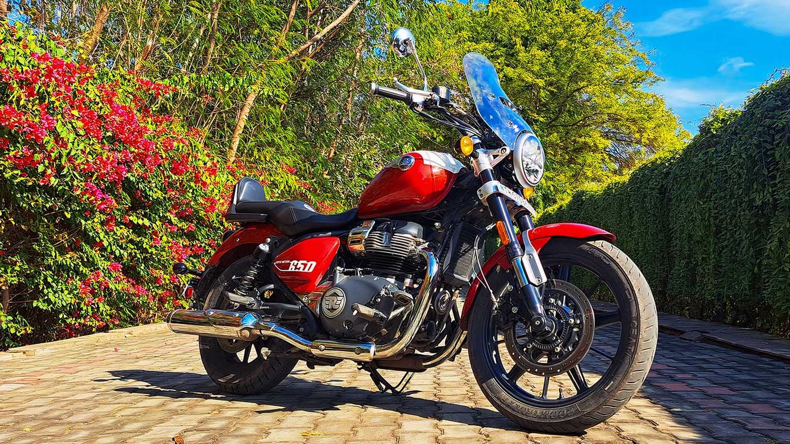 Static outdoor shot of a red Royal Enfield Super Meteor 650 with a windshield